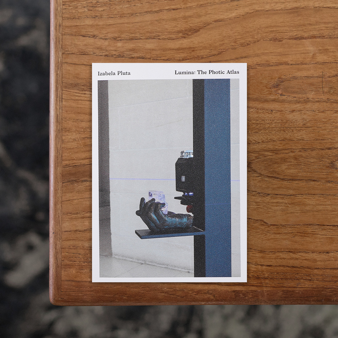 オーストラリアを拠点に活動するポーランド出身の写真家・Izabela Pluta（イザベラ・プルタ）が、メルボルン・ハイド近代美術館に在籍のキュレーター・Melissa Keys（メリッサ・キーズ）と一年以上にわたり対話をしながら取り組んだプロジェクト「Lumina」についてまとめた一冊。
このプロジェクトは、プルタがハイド近代美術館の近代建築をカメラであり無意識の共演者として捉え、窓や壁のガラスを通して自然光が差し込む場所に直接銀塩印画紙を置くことで、レンズを介さずに光と影を捉えたものです。
プルタはこの制作を通じて写真に雰囲気を宿す手がかりを掴み、のちに自身が幼少期を過ごしたポーランド・ワルシャワの自宅を訪ねて写真と動画の撮影に取り組みました。
本書ではそれぞれの制作過程やその後の派生にまつわる詳細が批評のエッセイとともにまとめられており、このプロジェクトの全貌を包括的に読み解くことができます。

#Lumina:ThePhoticAtlas#IzabelaPluta#PerimeterEditions#graphic#photo #photograph #designbook #artbook #photobook #photographer#design#art
