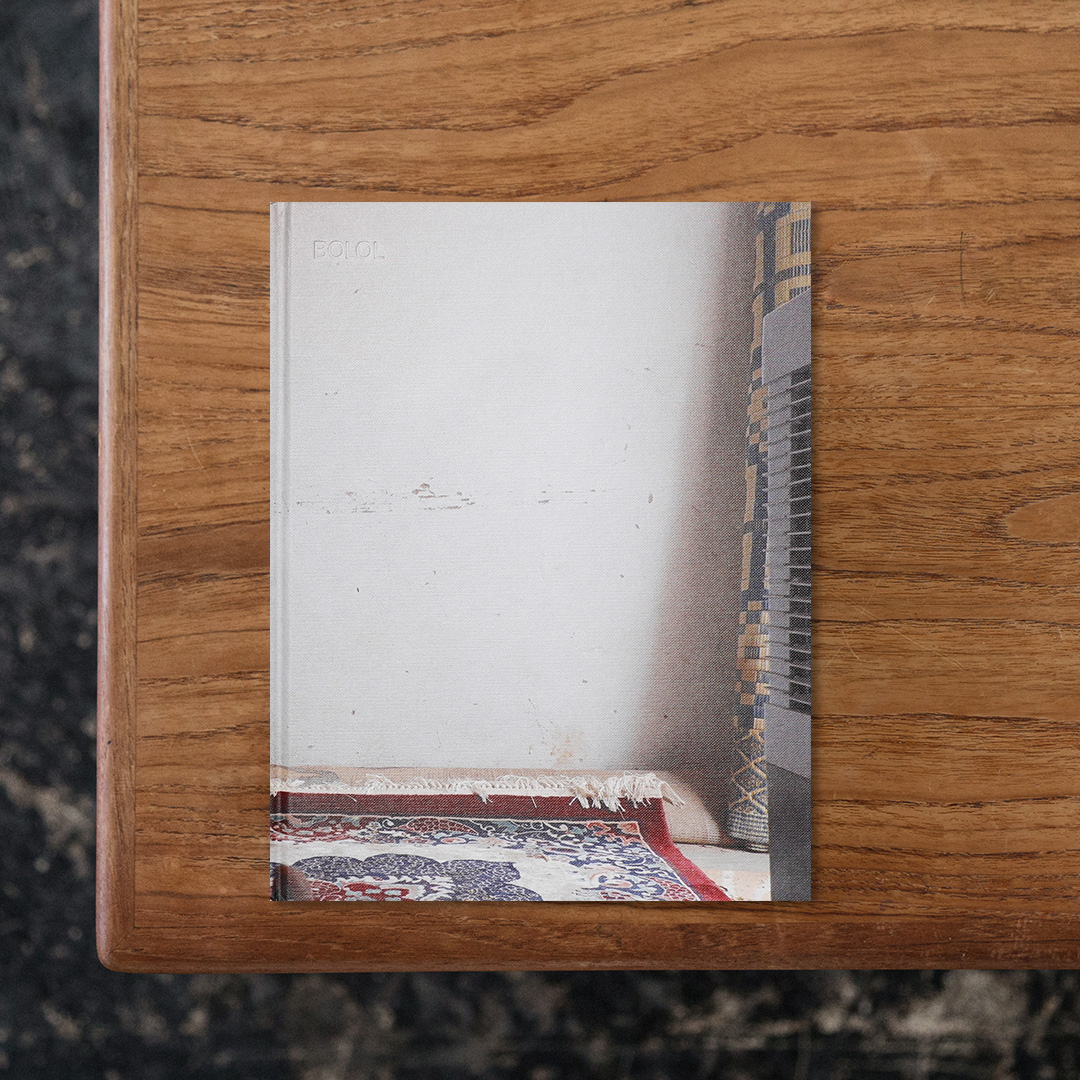 スイス出身で、現在はセネガルの首都ダカールを拠点に活動する写真家でヴィジュアルアーティストのEva Diallo（エヴァ・ディアロ）が、セネガルよりイタリアへと不法に移住した二人のいとこの証言をもとに足跡を辿ることで、「不法移民」の実情について当事者的な視点から探究した一冊。
2018年に自身の母の生まれ故郷であるセネガルから、マリやブルキナファソ、ニジェールなどの西アフリカ各地を巡って、彼らの最終的に辿り着いたイタリアまで旅をしたディアロであるが、そこで彼らが国境を不法な手段で超えたのに対して、自身はスイス国籍を有していることから自由に国を往来できるという出生を理由とした格差に直面。
その立場の違いに対してディアロは葛藤を抱えながらも真摯に彼らの行動に向き合い続けることで、彼らが移動中に経験した希望や犠牲、そしてユーロッパに対して抱いた憧れと現地で直面した現実などについて浮き彫りにしています。
本書ではディアロの繊細な眼差しを通じて、いとこたちが目にしたであろう風景や人物の数々が捉えられており、ここでは意図的に「不法移民」というキーワードで連想される紋切り型の写真を避けることで、「不法移民」という一筋縄にはいかない複雑な問題の有り様を鑑賞者に時間をかけて読み解くことを求めています。

#Bolol#EvaDiallo#CécileFakhoury#graphic#photo #photograph #designbook #artbook #photobook #photographer#design#art